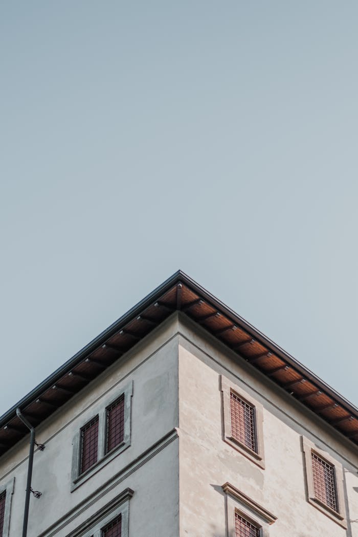 Low-angle view of a minimalist Italian building against a clear sky, showcasing architectural lines.